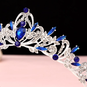 Detailed close-up of Baroque crown featuring silver alloy scrollwork and blue teardrop crystals