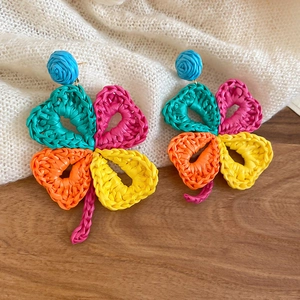 Close-up of colorful raffia woven flower earrings with handmade bohemian details