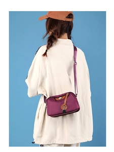 Vista dettagliata della borsa a tracolla in nylon bordeaux con eleganti dettagli in pelle