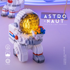 Close-up of astronaut building blocks with glowing LED helmet and flower bouquet details