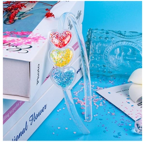 Detail of children's clear headband with liquid sand glitter hearts on light blue background