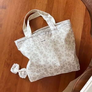 Detailansicht einer Baumwolltasche mit Blumenmuster und 'Simple Wish' Etikett