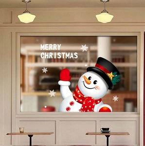 Close-up of a festive snowman window sticker with Merry Christmas text on cafe glass