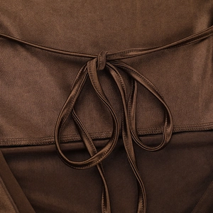 Close-up of elegant bow tie back design and smooth brown satin fabric texture