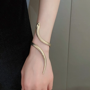 Close-up of a gold snake wrap bracelet worn on arm, showing metallic texture and detail