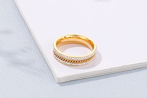Detail of gold titanium steel ring featuring a chain link center and double row of rhinestones