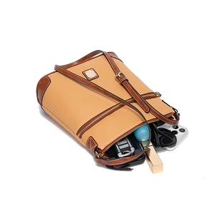 Detail of pebbled leather crossbody bag showing spacious interior and front zipper pocket
