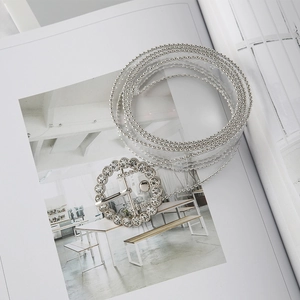 Close-up of transparent PVC belt with rhinestone buckle and silver bead chain trim