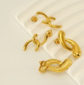 Detailed view of polished 18k gold plated geometric stud earrings with textured back