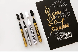 Detailed writing test of gold, silver and white 2.0mm metallic paint markers on black paper