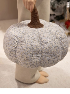 Detail of floral pumpkin plush pillow with blue fabric and soft brown stem texture
