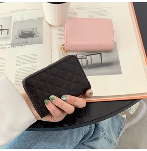 Close-up of quilted leather card holders in pink and black with golden zippers