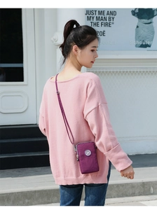 Détail d'un mini sac bandoulière en nylon violet avec zips et bandoulière réglable