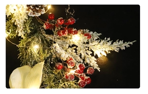Détail de branche de pin de Noël avec baies rouges et blanches et guirlande LED chaude