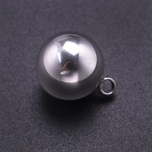 Détail macro d'un pendentif boule en acier inoxydable 304 poli avec fini métal brillant