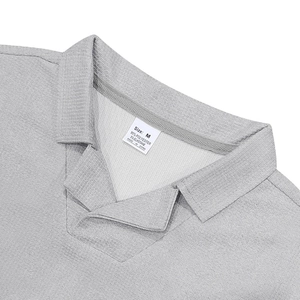 Primer plano del cuello de polo gris con tejido de gofres y etiqueta de composición textil