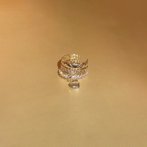 Detail of gold multi-layered ear cuff featuring a zircon band and heart pendant