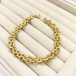 Detail of gold-plated punk bracelet featuring textured links and a lobster clasp closure