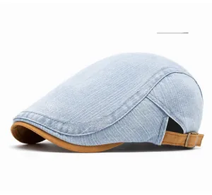 Detail of light blue denim ivy cap with brown fabric brim and adjustable metal buckle strap