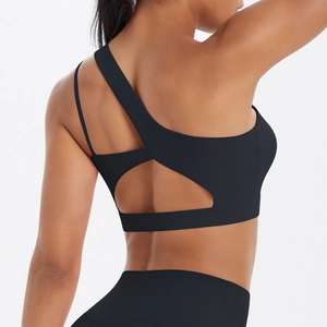Macro detail of asymmetric back strap design on a black sports bra with cutout features