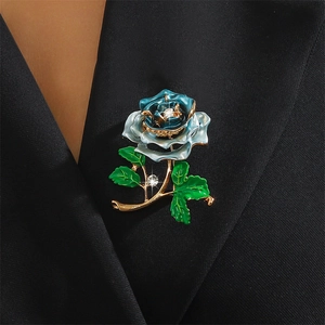 Detail view of a blue enamel rose brooch with crystals on a black suit lapel