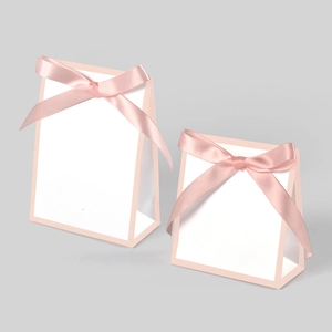 Detailed view of large and small pink trapezoid gift boxes with satin ribbon bows