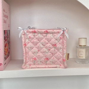 Detail of pink quilted storage basket with bunny print and white ribbon bows
