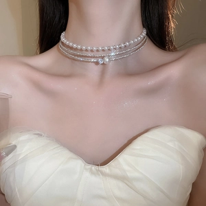 Close-up of multi-layer pearl and rhinestone choker necklace on female model