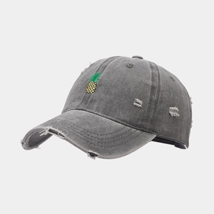Gros plan détaillé sur la broderie ananas d'une casquette délavée gris foncé usée