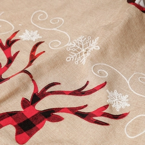 Macro detail of linen Christmas tree skirt with reindeer applique and snowflake embroidery