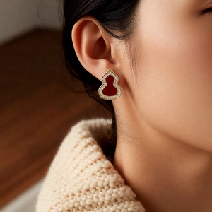 Close-up of red zircon wulu stud earrings in gold with white crystal pavé for women