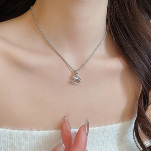 Detailed view of silver horse pendant necklace featuring sparkling zircon inlay on model