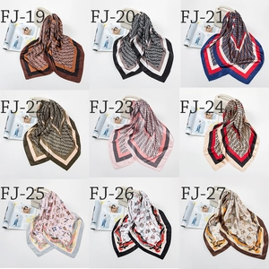 Selection of 90cm satin square scarves featuring classic vintage patterns on a white handbag