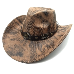 Detail of vintage brown cowboy hat with leather band and metal bull totem ornament