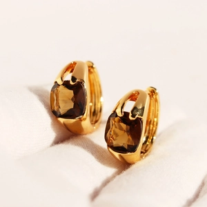 Elegant gold earrings featuring square cut emerald green zircons with minimalist style
