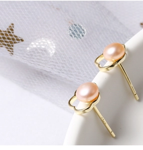 Macro detail of S925 sterling silver hallmark and pink freshwater pearl on gold stud