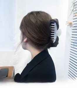 Rear view of model wearing a large pearlescent blue claw clip for a French hair bun