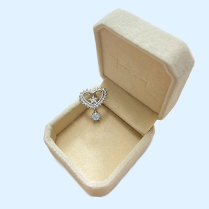 Close-up of silver heart belly button ring with crystals in a beige jewelry box