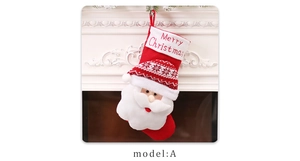 Detail of a red knitted Christmas stocking with a 3D Santa Claus figure on a fireplace