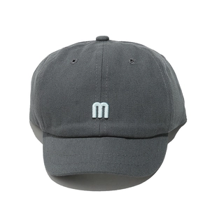 Gros plan détaillé d'une casquette en coton gris foncé avec logo m brodé blanc