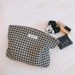Classic black and white houndstooth checkered cosmetic bag with woven fabric texture