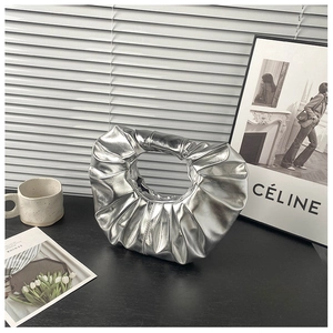 Makroaufnahme der silbernen Hobo-Tasche mit Falten-Design und metallischem Glanz im Raum