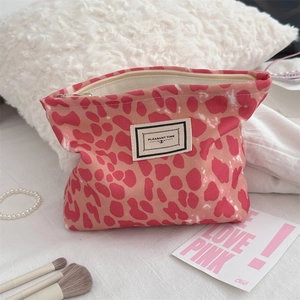 Dettaglio della borsa da trucco leopardata rosa in tela con cerniera in metallo
