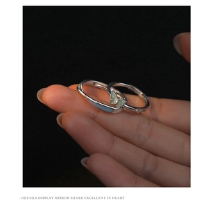 Detailed close-up of S925 sterling silver couple rings with green glow butterfly detail