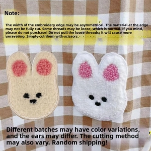 Detail of plush rabbit embroidery patches for baby curtains on plaid background