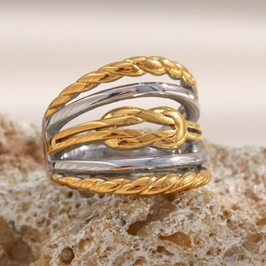 Détail macro d'une bague nœud multicouche plaquée or 18 carats sur fond de pierre