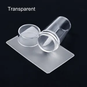 Close-up of clear nail art stamper set with scraper tool on black background