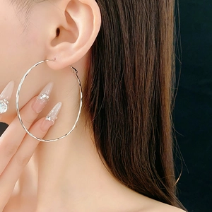 Orecchino a cerchio geometrico minimalista in argento indossato da una modella