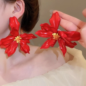 Close-up of red acrylic flower earrings with yellow stamen on model for beach style