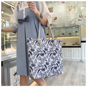 Detail of canvas tote bag with blue parrot leaf print and thick rope handles